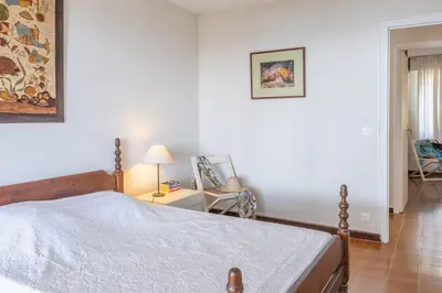 a bedroom with a bed and a table with a lamp at Villa Les 3 frères in San-Nicolao