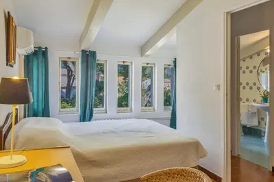 a bedroom with a bed and some windows at Villa Les 3 frères in San-Nicolao