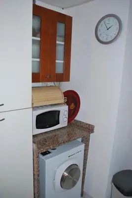 a kitchen with a microwave and a counter with a washing machine at L'Appart in Bonifacio