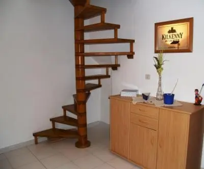 a wooden spiral staircase in a room with a wooden cabinet at L'Appart in Bonifacio