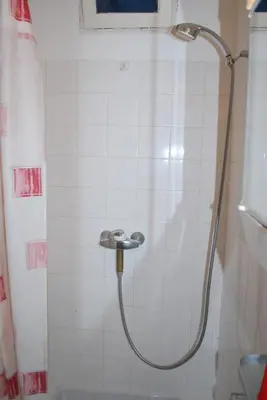 a shower with a hose in a bathroom at L'Appart in Bonifacio