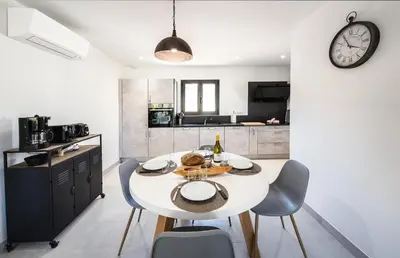 a kitchen and dining room with a white table and chairs at Résidence Petra d'Oro - Villa Chiappa in Porto-Vecchio