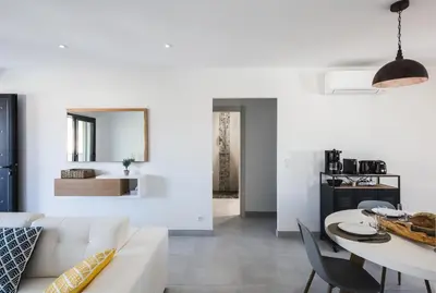 a living room with a white couch and a table at Résidence Petra d'Oro - Villa Chiappa in Porto-Vecchio