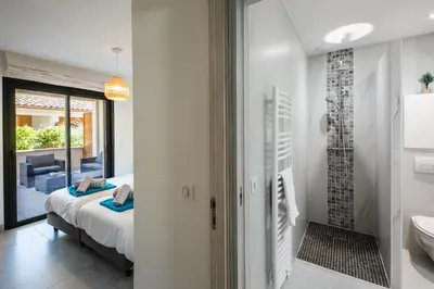 a bedroom with a bed and a bathroom at Résidence Petra d'Oro - Villa Chiappa in Porto-Vecchio