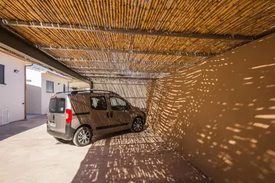 a small car parked in a garage with a roof at Résidence Petra d'Oro - Villa Chiappa in Porto-Vecchio