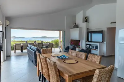 a dining room with a wooden table and chairs at Villa Bella Vista Di Pinarello in Sainte-Lucie de Porto-Vecchio