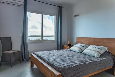 a bedroom with a bed with a large window at Villa Bella Vista Di Pinarello in Sainte-Lucie de Porto-Vecchio