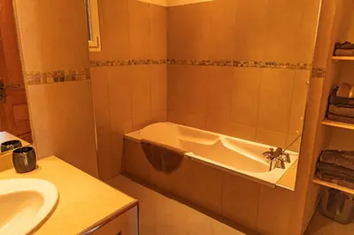 a bathroom with a bath tub and a sink at Villa Bella Vista Di Pinarello in Sainte-Lucie de Porto-Vecchio
