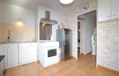 a kitchen with a stainless steel refrigerator and white cabinets at Amazing Home In Borgo With Kitchen in Borgo
