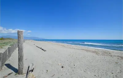 a beach with a wooden fence and the ocean at Amazing Home In Borgo With Kitchen in Borgo