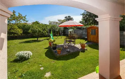a backyard with a table and an umbrella and a swing at Amazing Home In Borgo With Kitchen in Borgo
