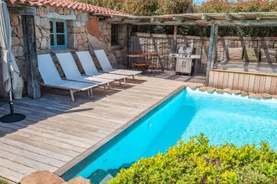 a deck with chairs and a swimming pool at Casa Sarralonga Di Porto-Vecchio in Porto-Vecchio