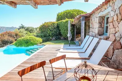 a villa with a swimming pool and a wooden deck at Casa Sarralonga Di Porto-Vecchio in Porto-Vecchio