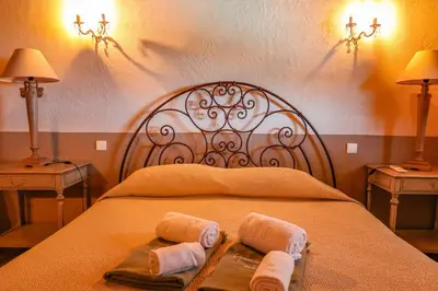 a bed with two towels and two tables with lamps at Casa Sarralonga Di Porto-Vecchio in Porto-Vecchio