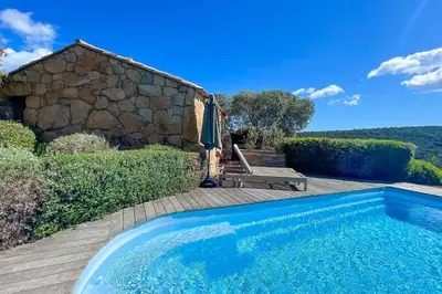 a swimming pool in front of a stone house at Casa Palombaggia Di Porto-Vecchio in Porto-Vecchio