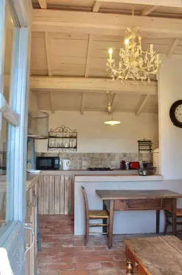 a kitchen with a dining table and a chandelier at Casa Palombaggia Di Porto-Vecchio in Porto-Vecchio