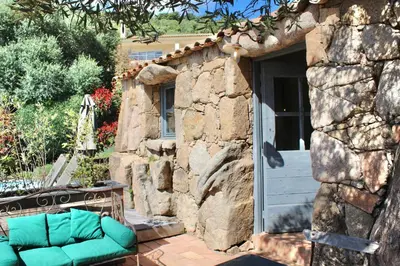 a couch sitting outside of a stone house at Casa Palombaggia Di Porto-Vecchio in Porto-Vecchio
