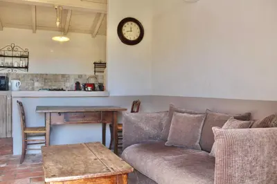 a living room with a couch and a clock on the wall at Casa Palombaggia Di Porto-Vecchio in Porto-Vecchio