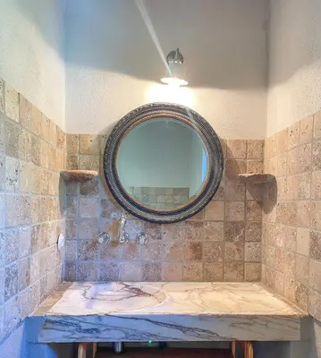 a bathroom with a mirror on a tiled wall at Casa Percale Di Porto-Vecchio in Porto-Vecchio