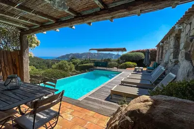 a swimming pool with a deck and chairs and a house at Casa Percale Di Porto-Vecchio in Porto-Vecchio