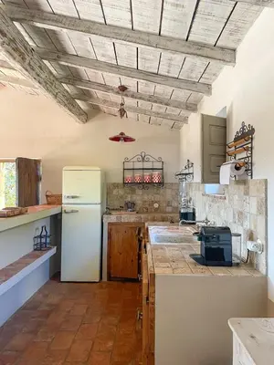 a kitchen with a white refrigerator and wooden cabinets at Casa Percale Di Porto-Vecchio in Porto-Vecchio