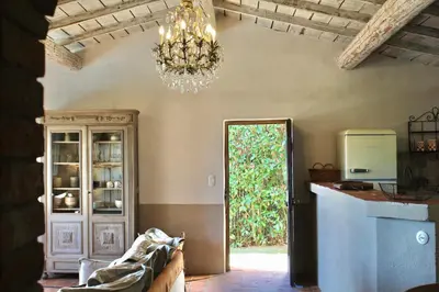 a dining room with a chandelier and a kitchen at Casa Percale Di Porto-Vecchio in Porto-Vecchio