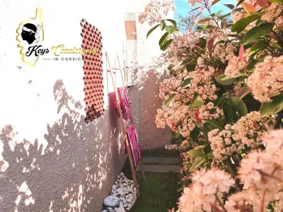 a garden with pink flowers and a wall at Maison de Plage à pied San Cipriano 5 pers in Lecci