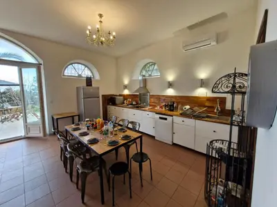 a kitchen with a table and chairs in a room at VILLA BELVEDERE D'AJACCIO, VILLA ENTIERE VUE MER POUR 2 à 10 VOYAGEURS in Ajaccio