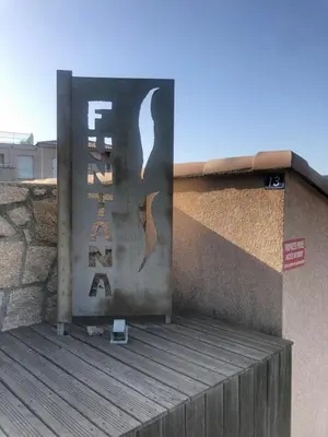 a sign on the side of a building at A Funtana deux chambres, vue mer, piscine et tennis in Propriano