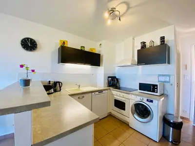 a kitchen with a washing machine and a sink at A Funtana deux chambres, vue mer, piscine et tennis in Propriano