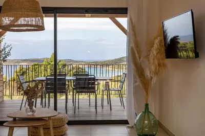 a dining room with white walls and a table with baskets at Casa Marina Cargèse in Cargèse