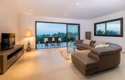 a living room with a couch and a television at VILLA TORRACCIA 4 Étoiles in Sainte-Lucie de Porto-Vecchio