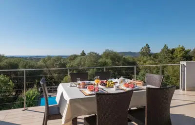 a table with food on top of a balcony at VILLA TORRACCIA 4 Étoiles in Sainte-Lucie de Porto-Vecchio
