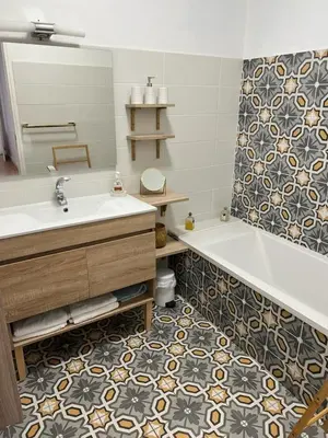 a bathroom with a tub and a sink and a mirror at Appartement climatisé F3 proche plage port et aéroport in Ajaccio