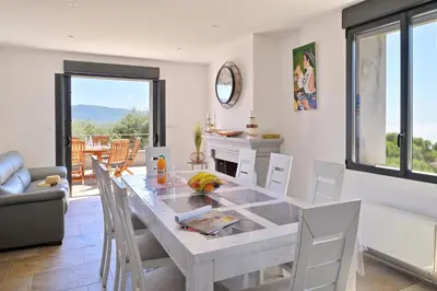 a dining room with a white table and chairs at Résidence Capicciolo Villa A CIGALA in Olmeto