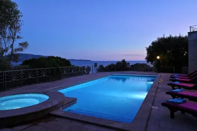 a swimming pool with lounge chairs around it at night at Résidence Capicciolo Villa A CIGALA in Olmeto