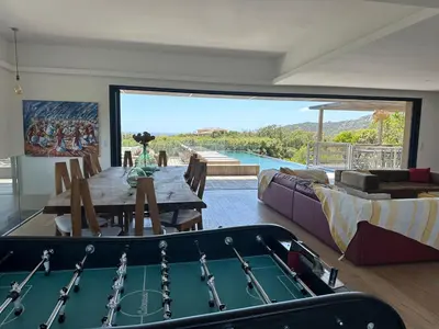 a living room with a pool table and a room with a pool table at Villa de luxe surplombant la mer, piscine suspendue in Pianottoli-Caldarello