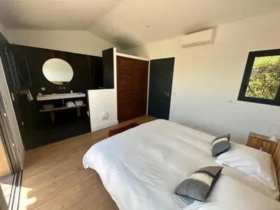 a bedroom with a large white bed and a mirror at Villa de luxe surplombant la mer, piscine suspendue in Pianottoli-Caldarello