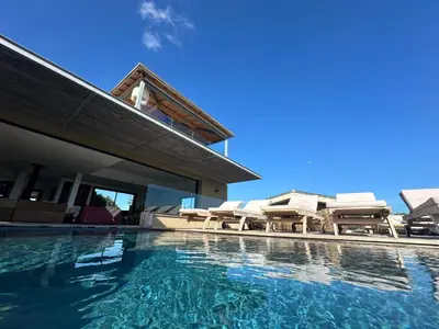 a swimming pool with lounge chairs and a house at Villa de luxe surplombant la mer, piscine suspendue in Pianottoli-Caldarello