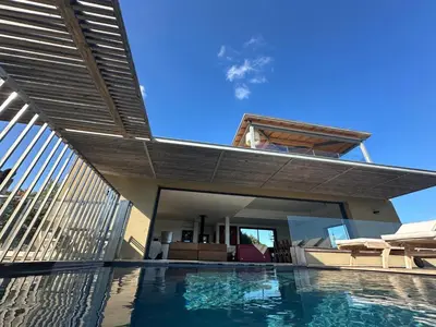 a house with a swimming pool with a roof at Villa de luxe surplombant la mer, piscine suspendue in Pianottoli-Caldarello