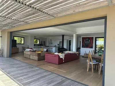 a living room with a couch and a table at Villa de luxe surplombant la mer, piscine suspendue in Pianottoli-Caldarello