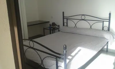 a bedroom with a bed with a metal frame at Jardins de Quatrina in Propriano