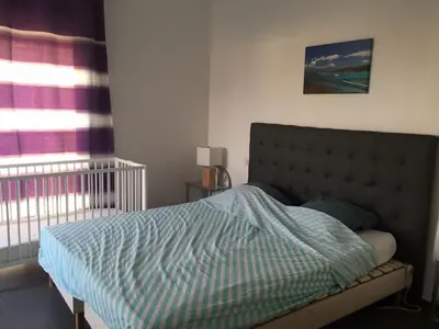 a bedroom with a bed with a blue comforter and a window at Marina d'Oro in Propriano