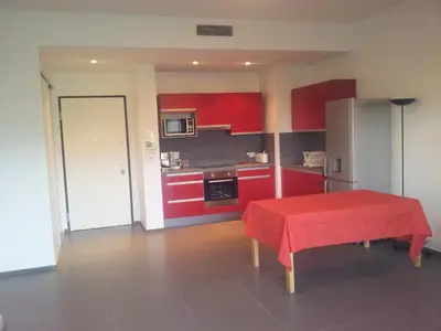 a kitchen with red cabinets and a table with a red table cloth at Marina d'Oro in Propriano