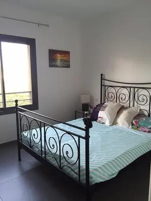 a bedroom with a black bed with pillows on it at Marina d'Oro in Propriano