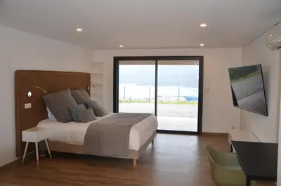 a bedroom with a bed and a sliding glass door at casa funtana d u frusteru in Propriano
