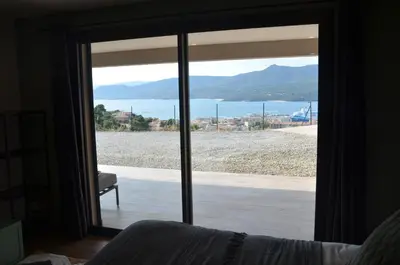a sliding glass door with a view of the ocean at casa funtana d u frusteru in Propriano