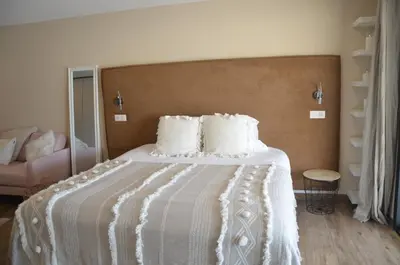 a bedroom with a bed with a white comforter at casa funtana d u frusteru in Propriano