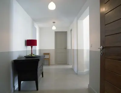 a hallway with a dresser and a door with a lamp on it at Les Salins in Porto-Vecchio