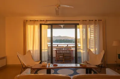 a living room with a couch and a table and chairs at Les Salins in Porto-Vecchio